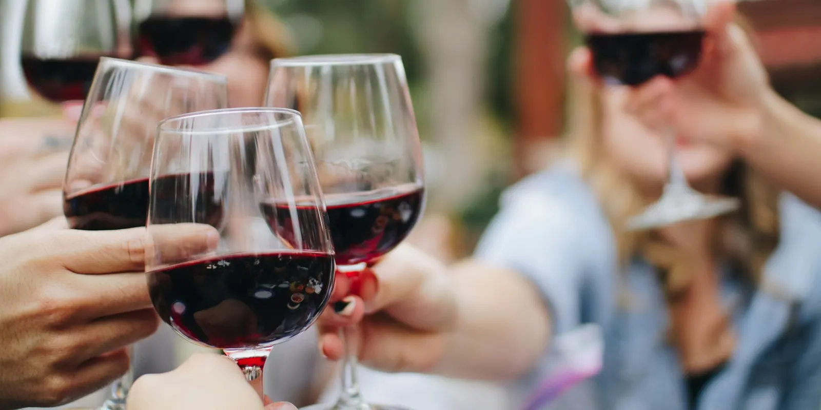 Amigos brindando con copas de vino tinto en una degustación