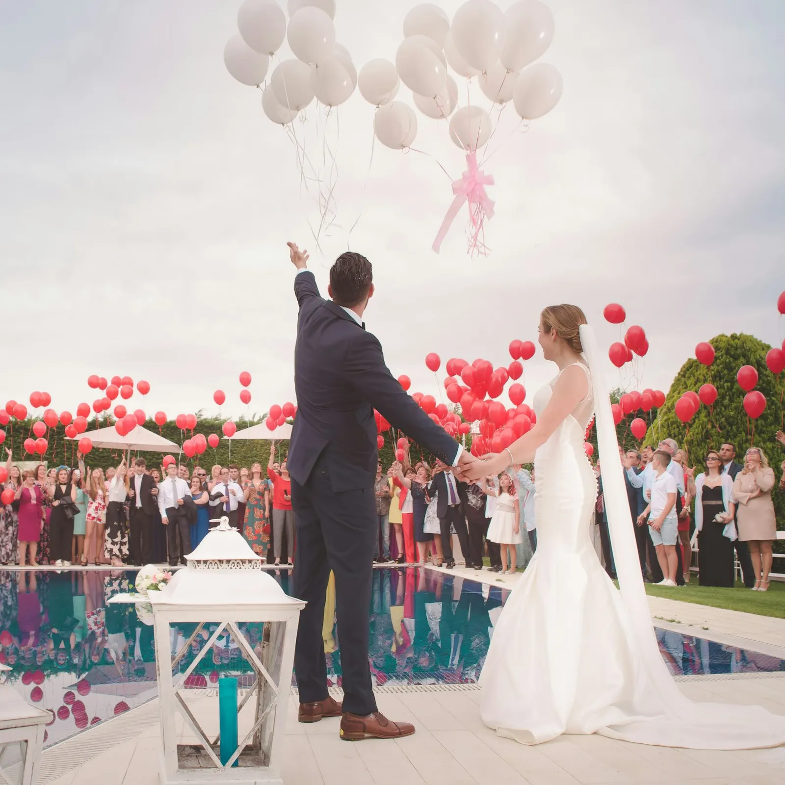 novios soltando globos blancos frente a los invitados