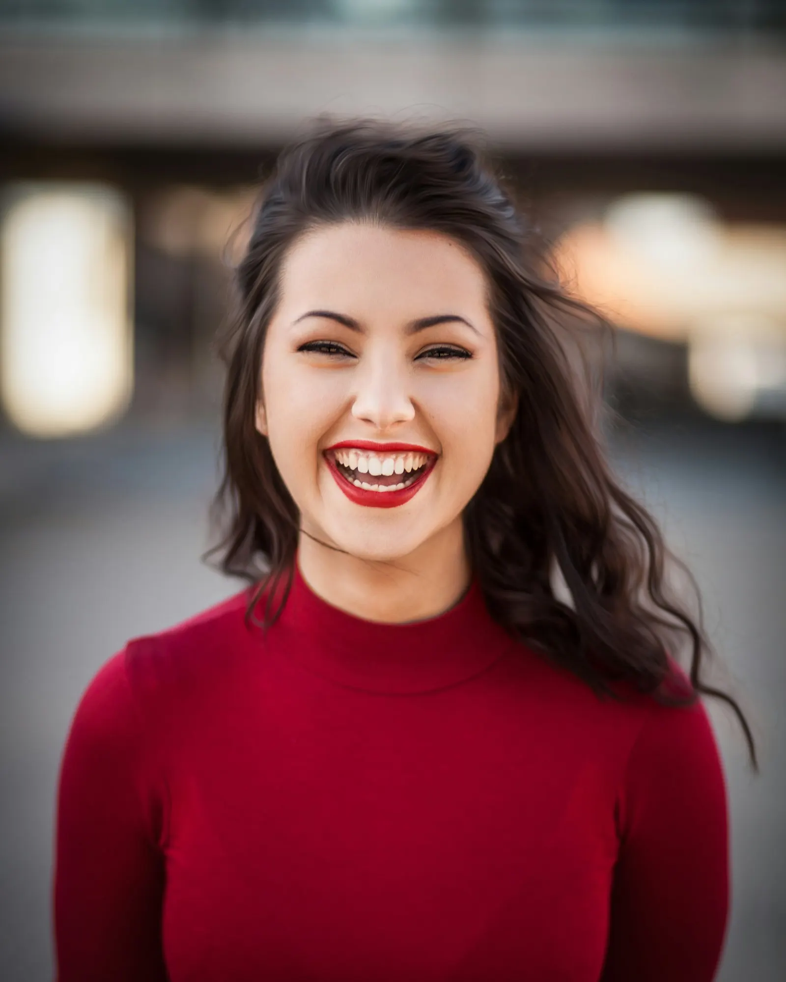 retrato de mujer riendo con suéter rojo