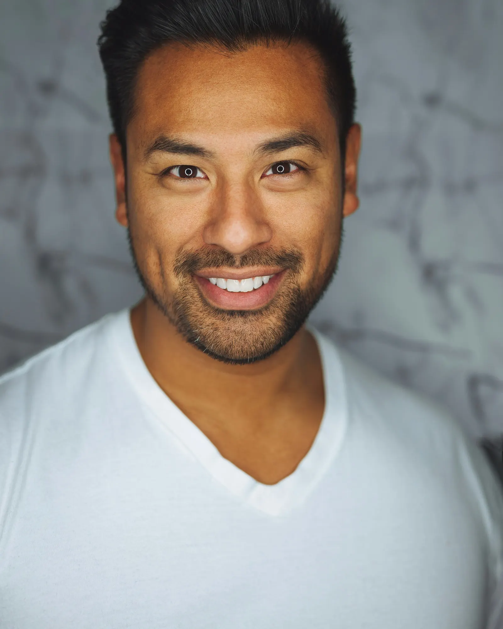 retrato de hombre sonriendo con remera blanca
